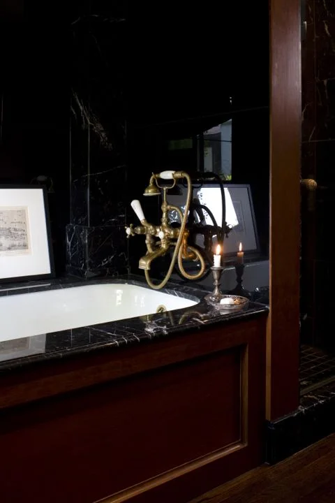 Old World glamour is brought to my bathroom with a black glass and marble tub, vintage brass faucets and cherrywood accents. (Casey Design/Planning Group Inc. - Photo by Ted Yarwood)