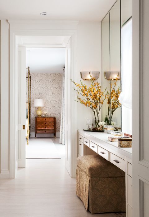 A clean contemporary makeup area featuring 1930's brass sconces and hardware that leads from the walk-in closet to the master suite's four-poster brass bed. (Casey Design/Planning Group Inc. - Photo by Donna Griffith)