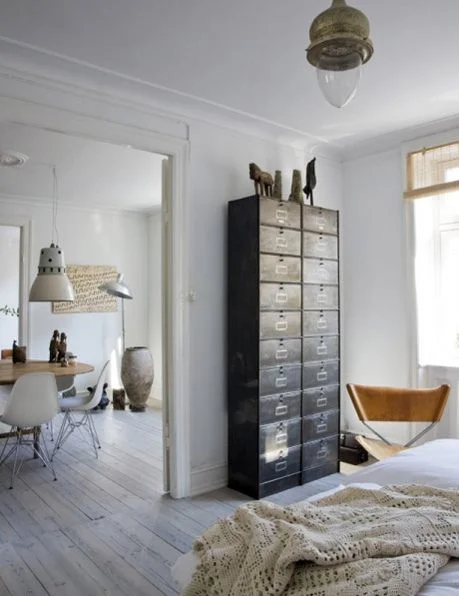 The soft, multi-texutred tan and white color theme with the accent of the vintage brown metal cabinet creates a classic, calm and groovy apartment ( Flickr ).