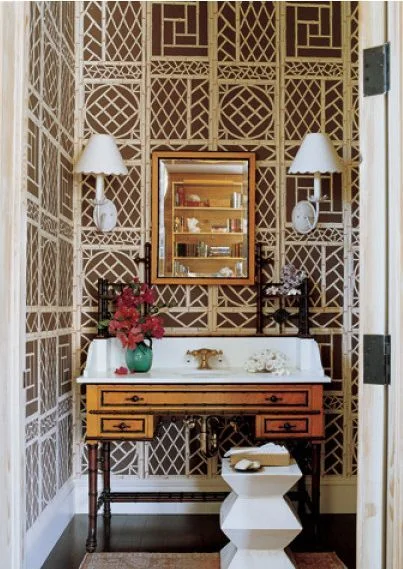 The brown and white wallpaper layered with the vintage vanity makes this powder room a knock out ( Mark D Sikes ).