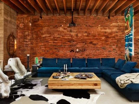 This indigo sofa contrasts wonderfully against the red brick backdrop - inviting and rustic. (Veronica Love Archie ).