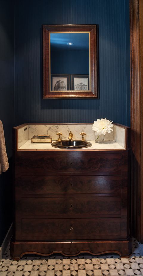 The indigo pinstriped wallpaper is a foil for this antique cabinet-turned-vanity for this powder room. It pairs beautifully with the custom designed mosaic floor - so rich and lively. (Casey Design/Planning Group Inc. - Photos by Ted Yarwood).