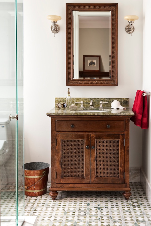 This Ensuite designed for a teenage boy is masculine but not boring - inspired by the British Raj, this ensuite has a "clubby" feel to it. The key elements are the patterned green, custom floor tiles and coordinating marble top, the textured cane vanity, the Waterworks Astoria Faucet and another one of my signatures - a pair of vintage sconces. The result: a bathroom that has no age limits!