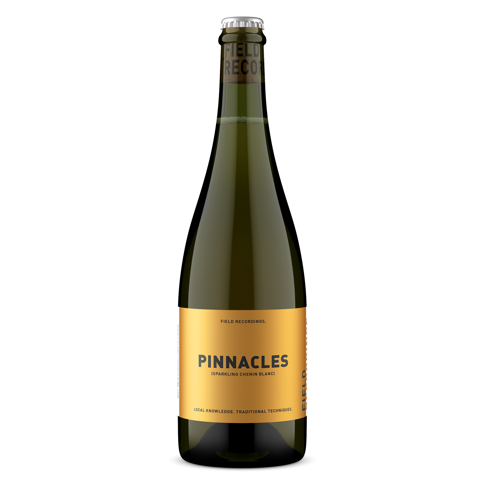 A sparkling wine glass bottle with a shiny gold label that has green text reading "Pinnacles," a sparkling Chenin by Field Recordings.