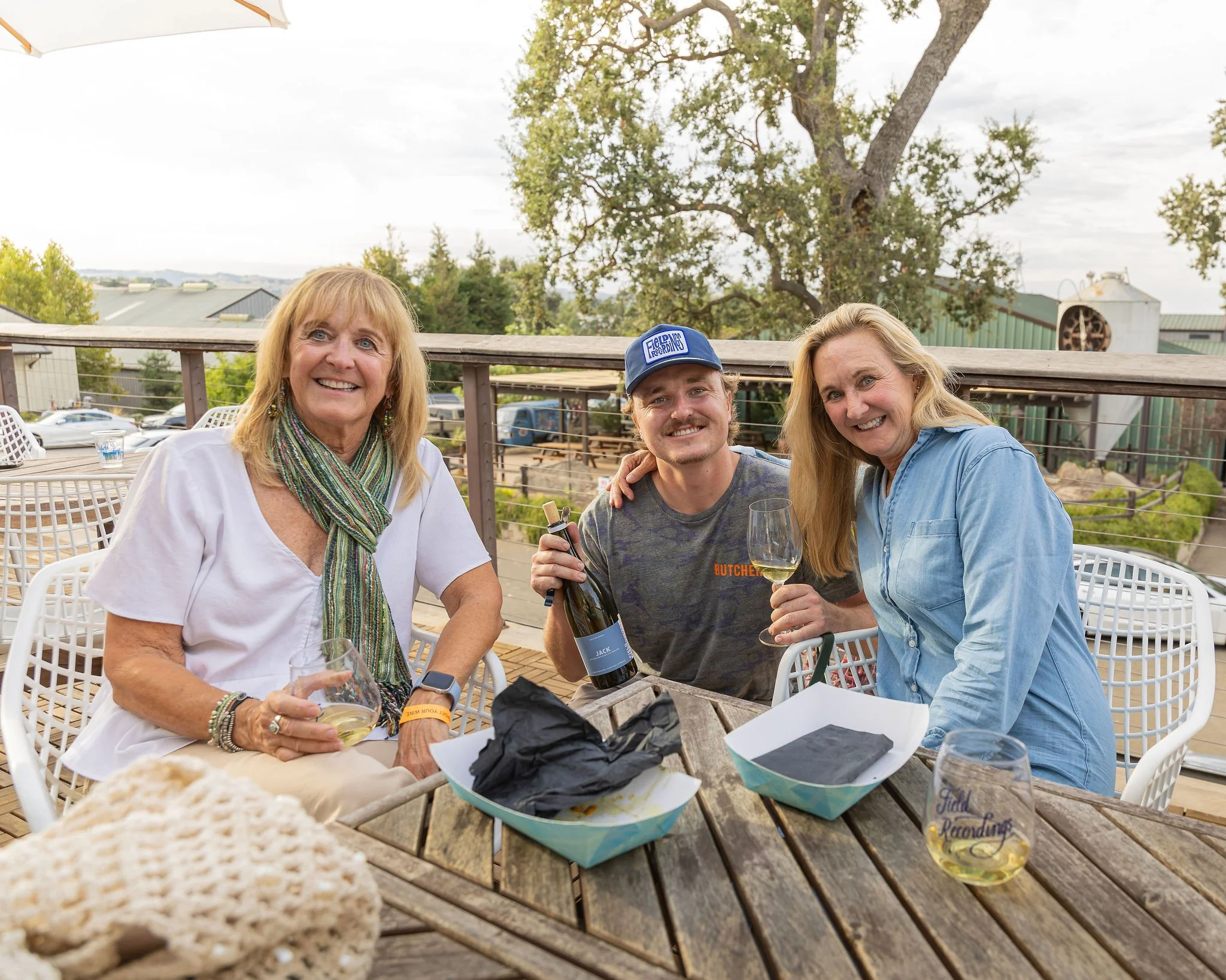 Jack sits with two family members and poses with his wine.