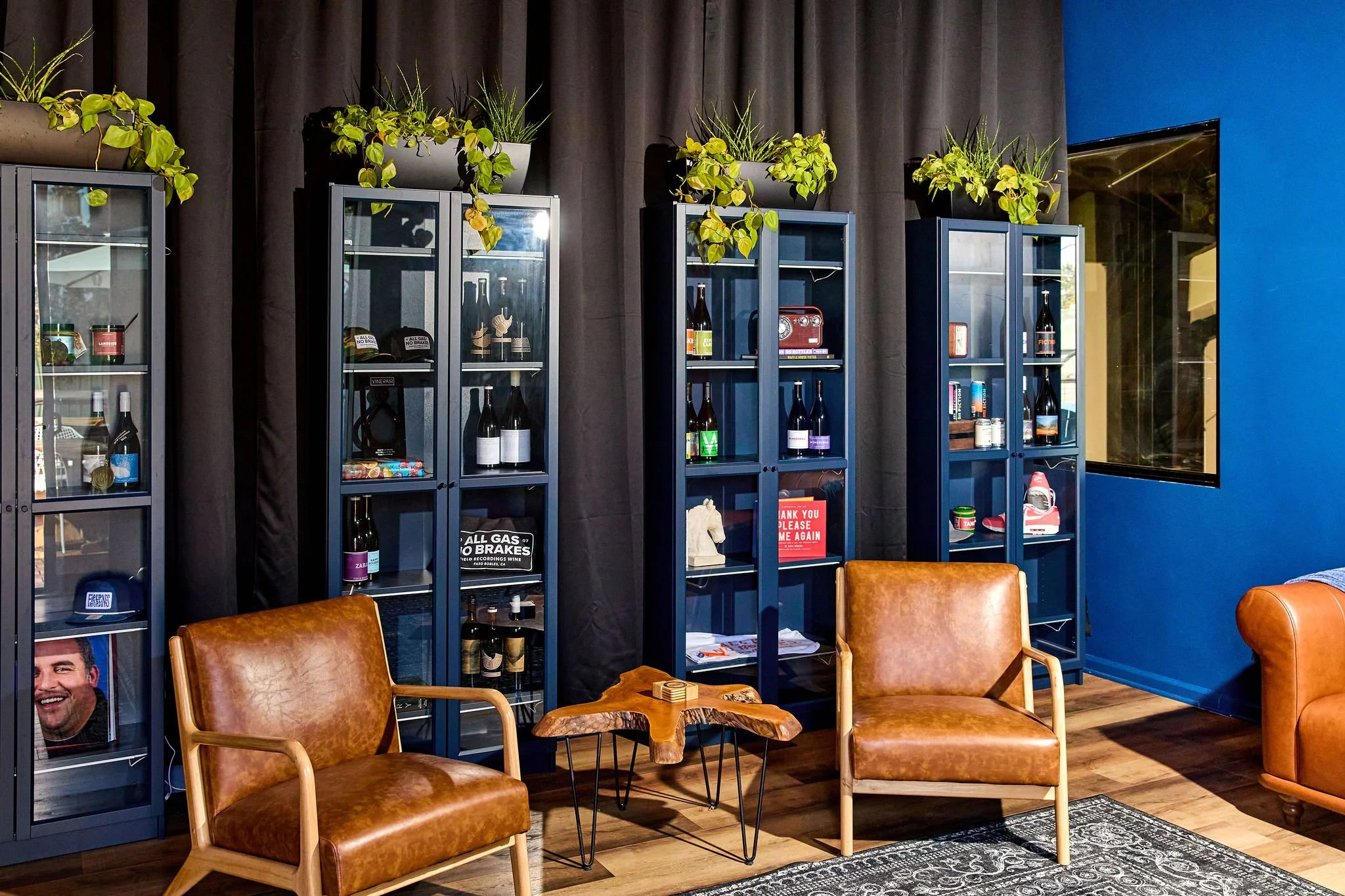 Two chairs in front of blue cabinets and a black curtain background.