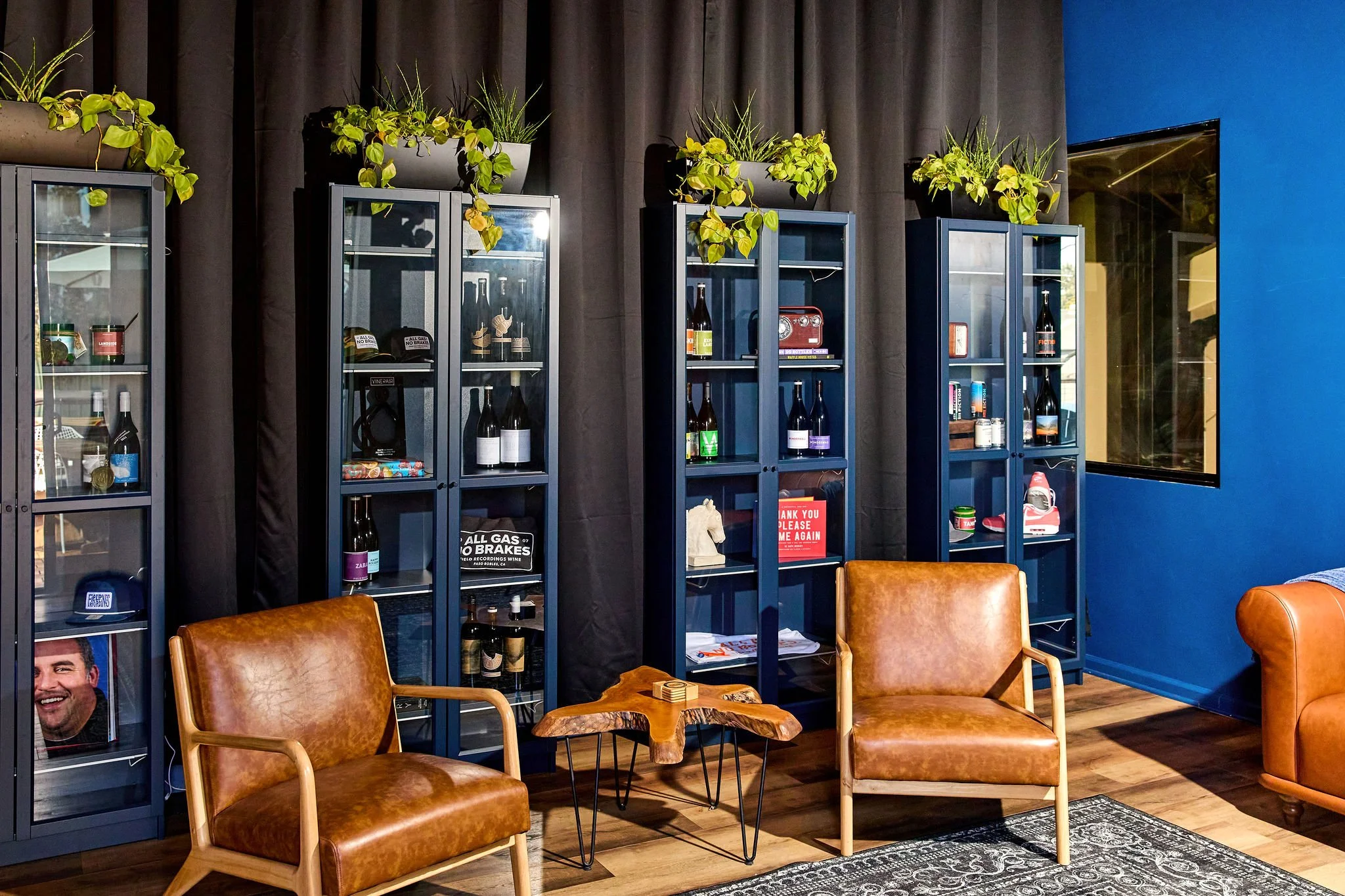 Two chairs in front of blue cabinets and a black curtain background.