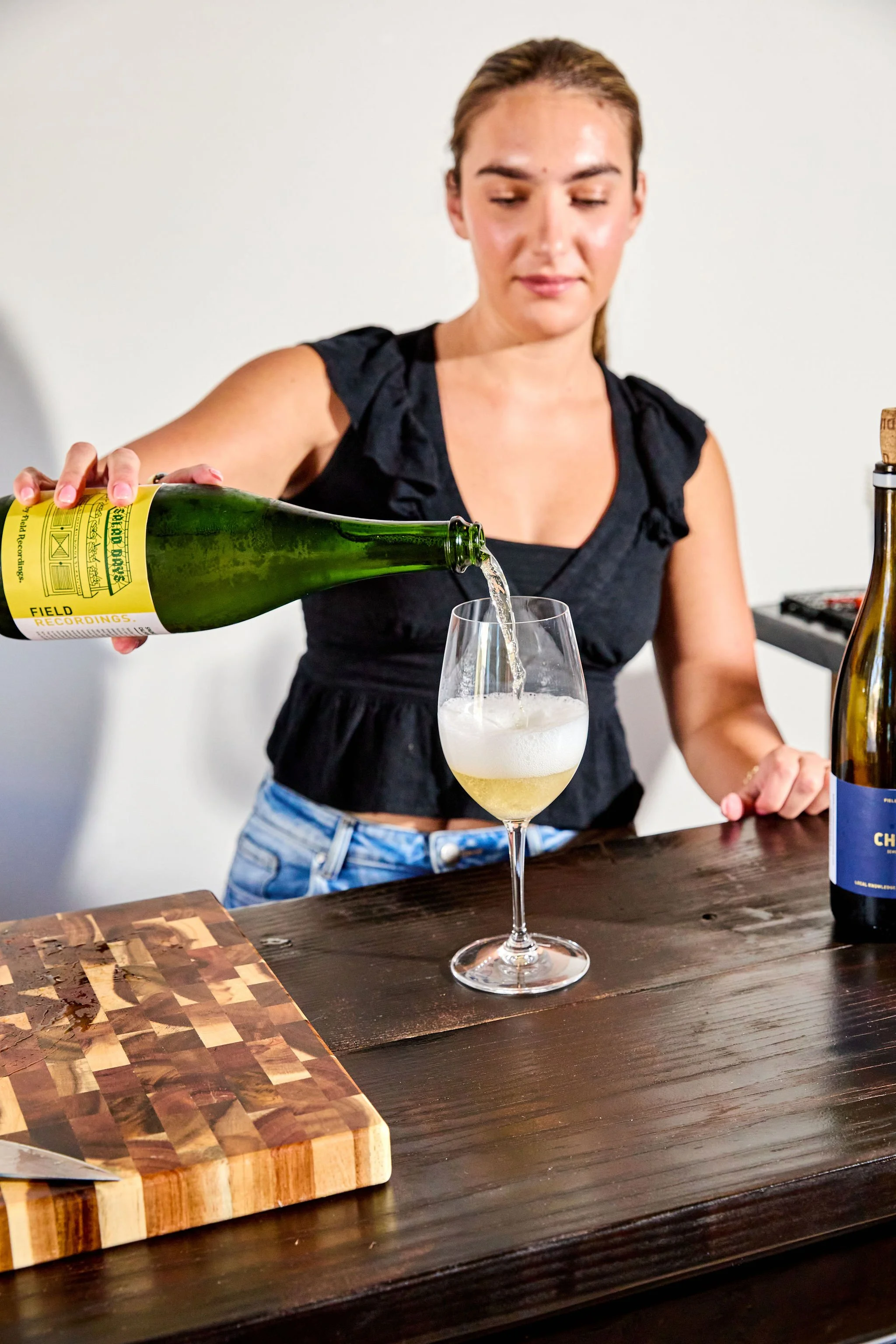 Isabelle pours a glass of bubbly wine behind the Aperitivo bar.
