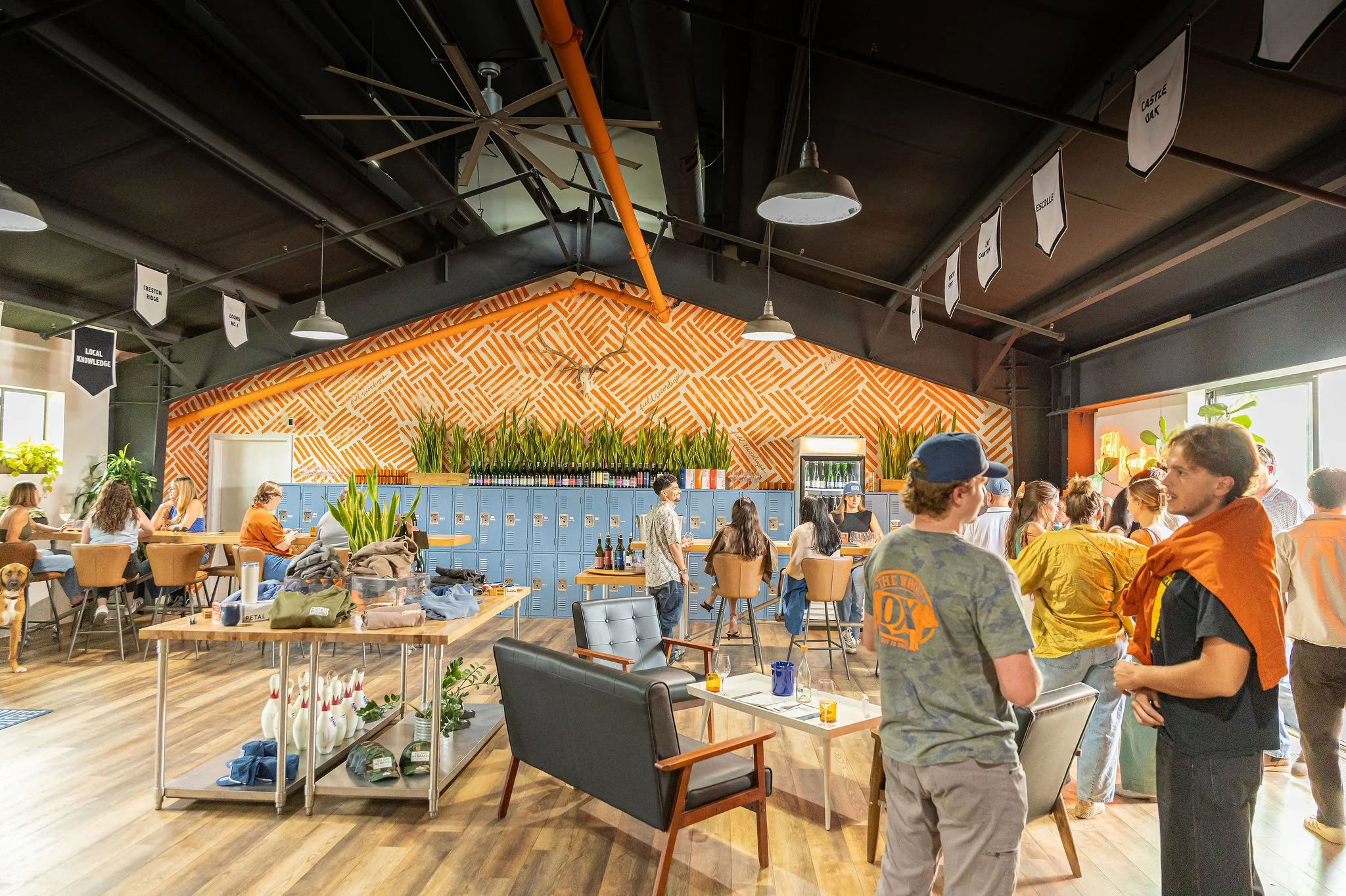 A wide shot of the tasting room, with people talking throughout the room.