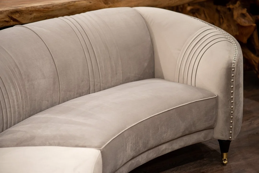 grey velvet Cypress rounded sectional  with hand hammered studs and pleats. Blue Moon furniture's bend upholstery collection.