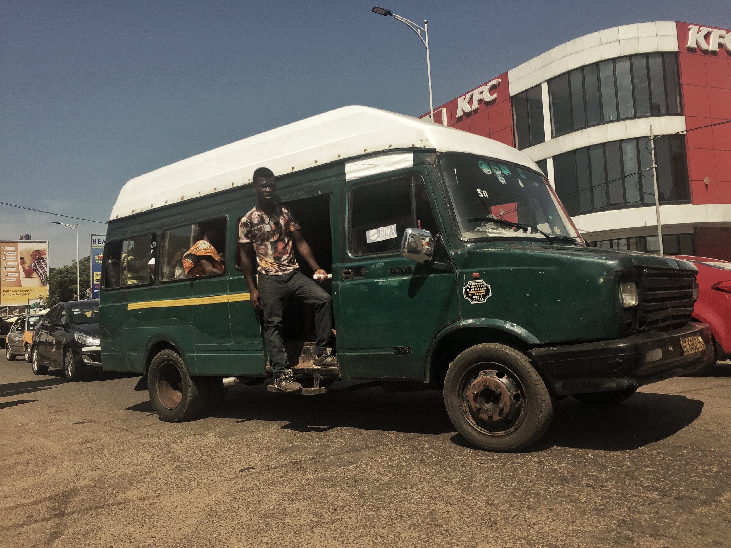 The mate of this trotro calls out destinations to passengers and collects fares.