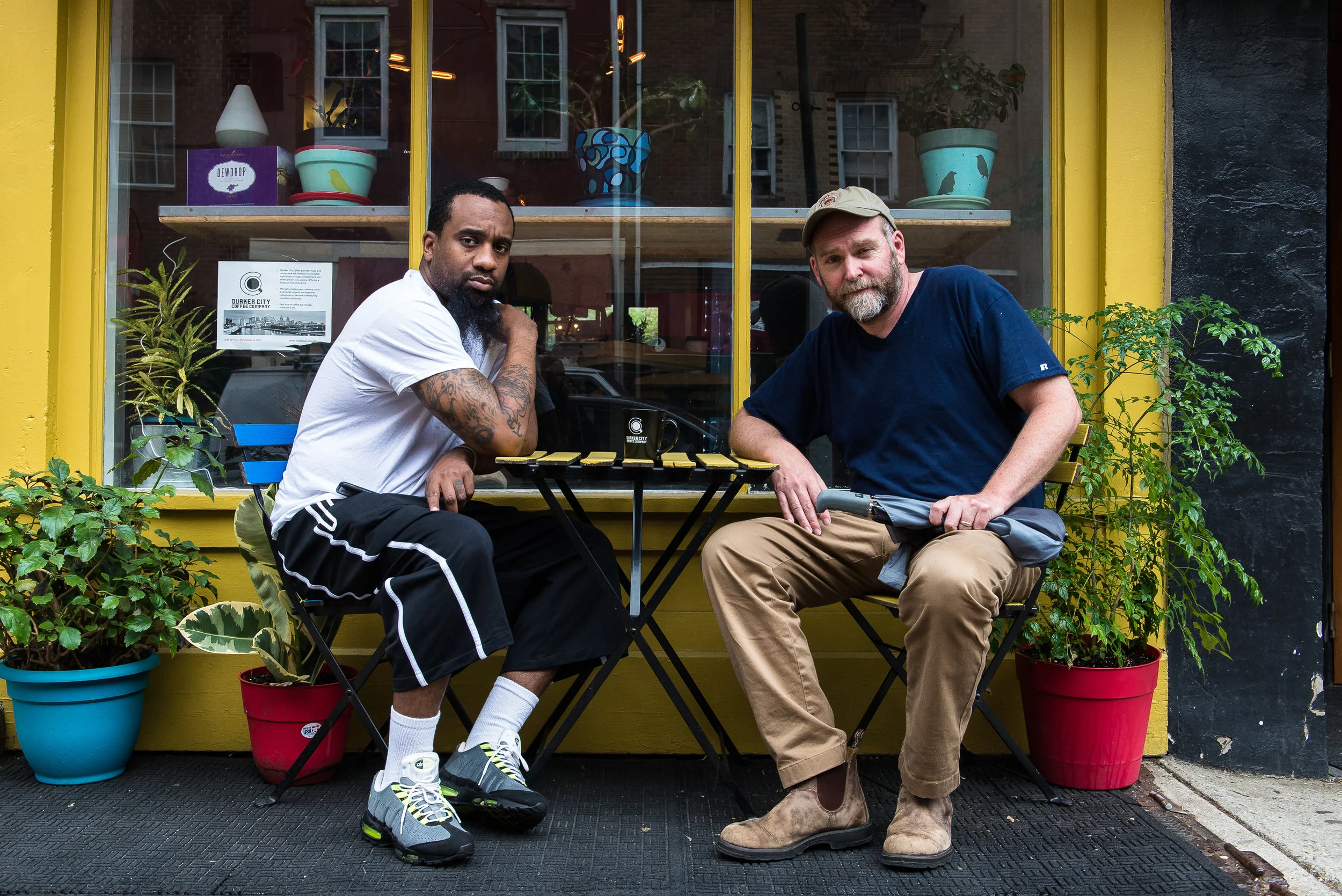 Christian Dennis and Bob Logue, co-owners of Quaker City Coffee, sit outside their coffee shop in Philadelphia
