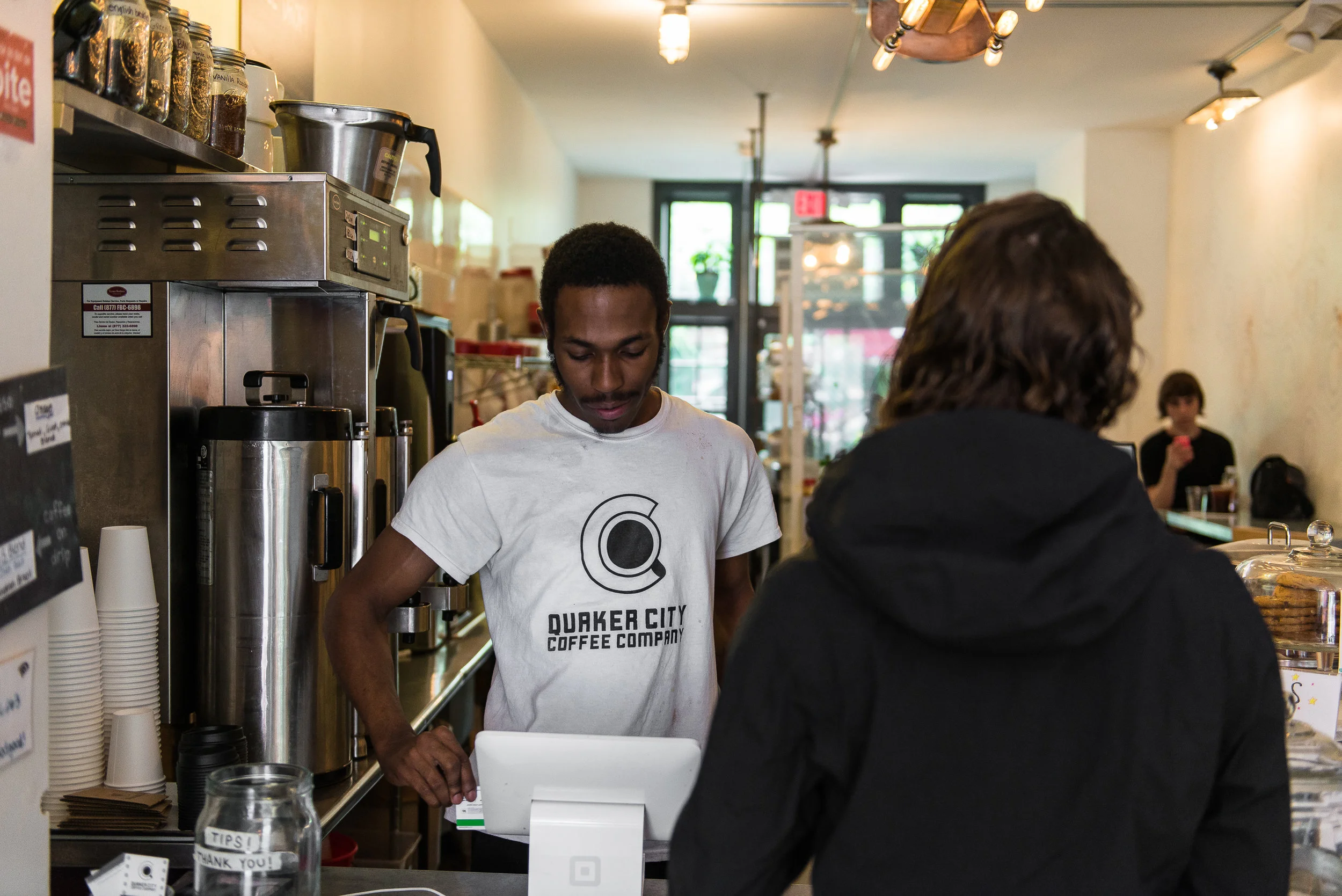 Jayson McCoy, a barista at Quaker City Coffee, tends to a customer.