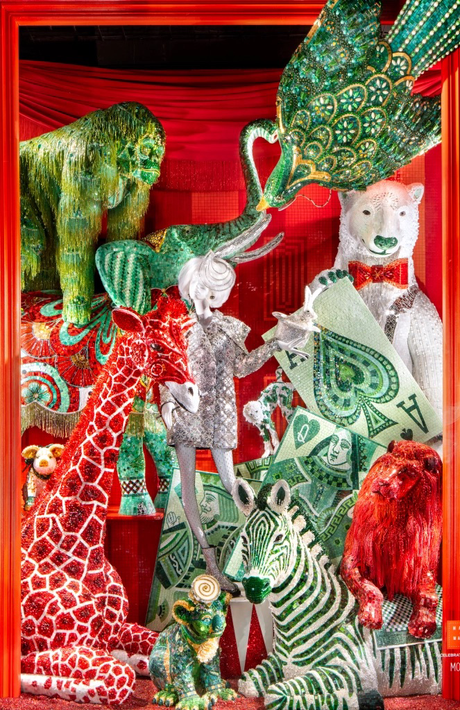 Colorful display of circus animal sculptures carved from or decorated with dollar bills, featuring a zebra, a giraffe, a lion, an elephant, a tiger, and a polar bear, set against a red background.