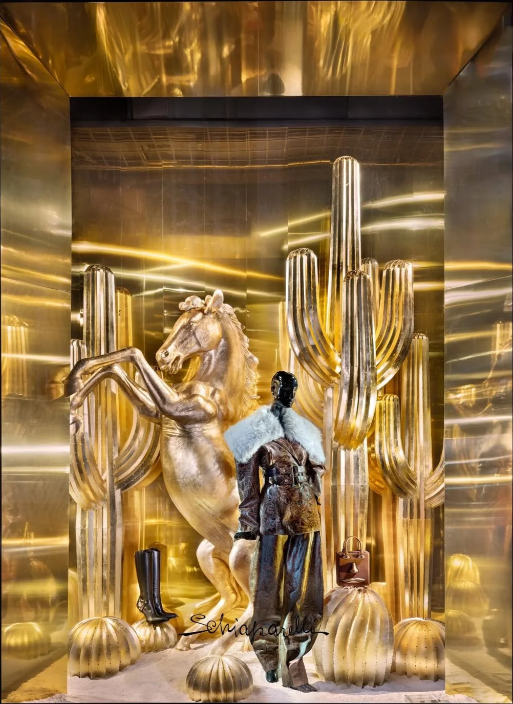 Display window with shelves of colorful yarn spools arranged in rows and the word 'ANTHROPOLOGIE' spelled out in red letters.