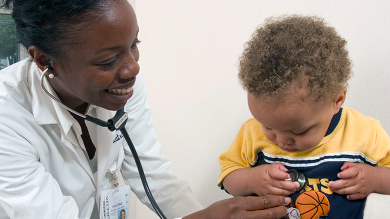 Dr. Burke Harris helps a patient.