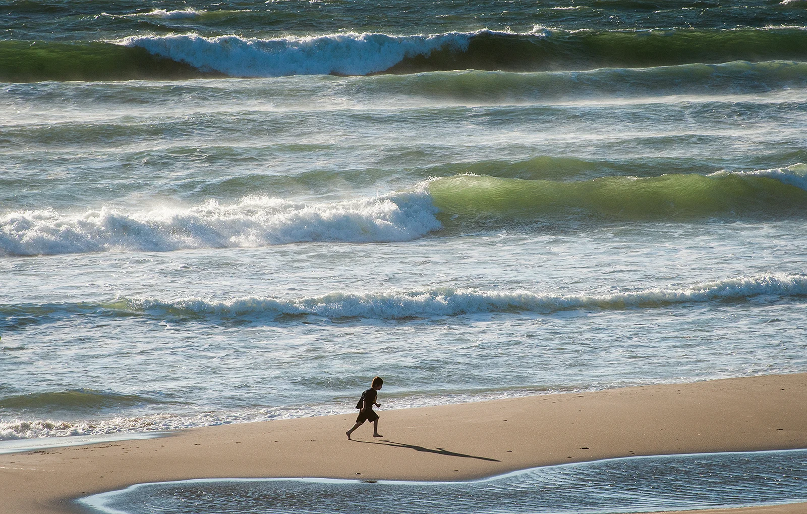 Young boy runs along the beach at Road's End State Recreation Site in Lincoln City. Photo by Rich Iwasaki