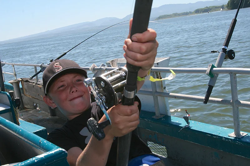 Pull and reel for 50 minutes -- that's what Rayne Ely, 11, of Sherwood had to do to catch his sturgeon. Photo by Roger Jensen