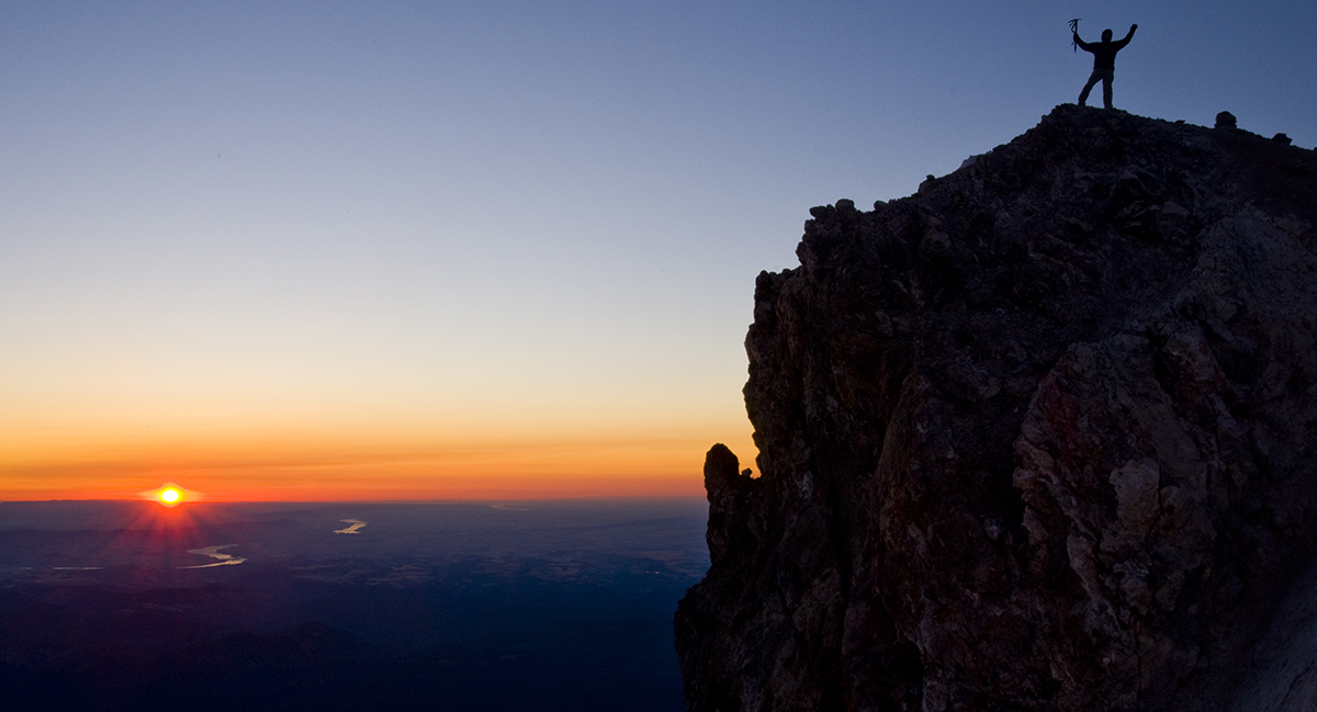 Dick Arnold celebrates sunrise from the top of Mt. Hood. Photo by Peter Marbach