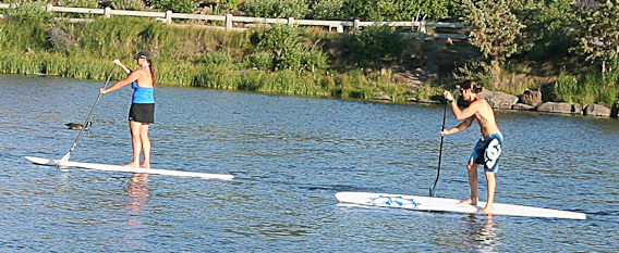 A couple paddle boarding on the Deschutes River in Bend. Photo by Marji Parker