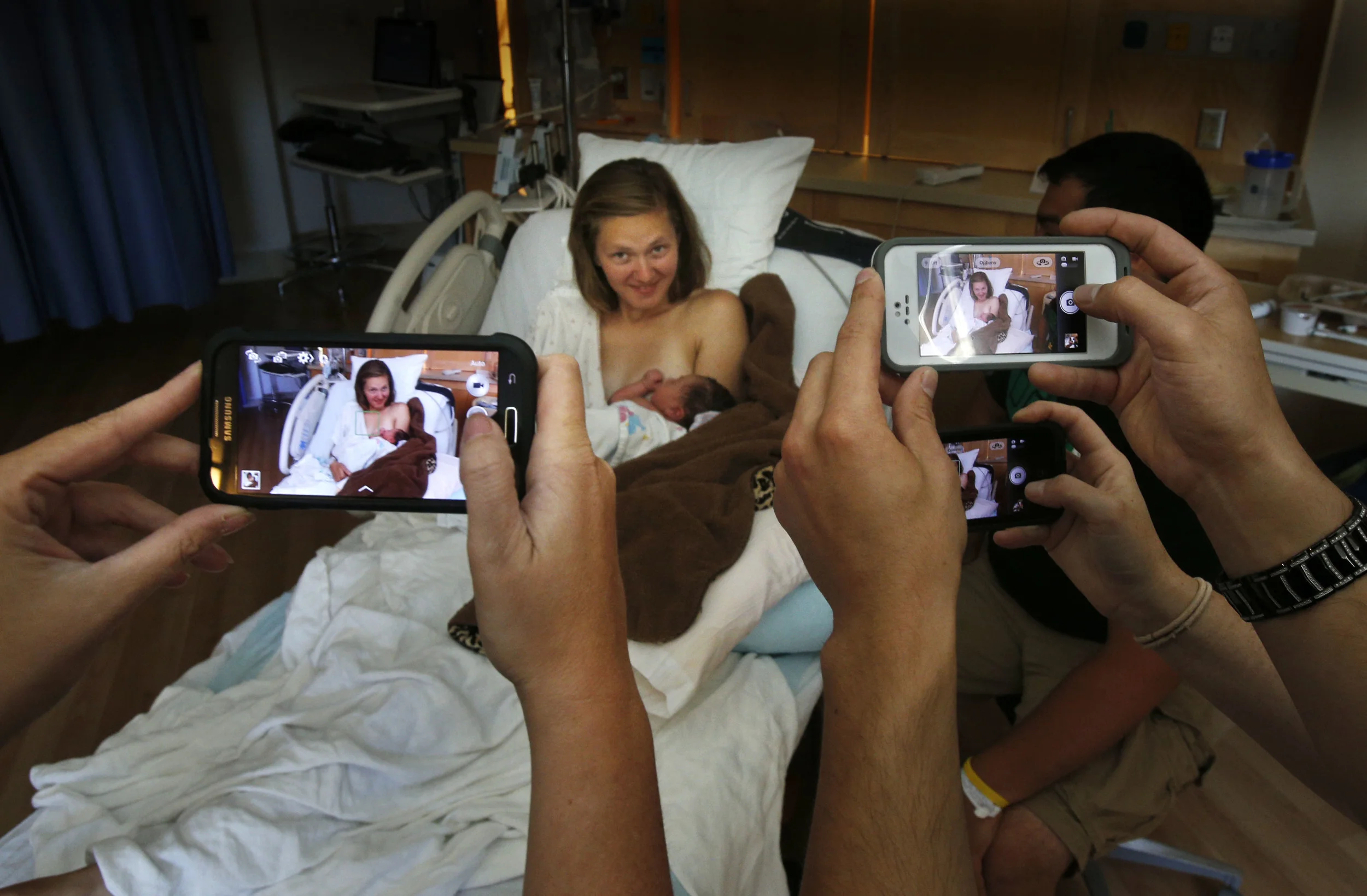 3:24 p.m. � Family members gather around with cell phone cameras to take pictures of newborn Arianna Delgado with her mother Kaila Chrisman, 19, after her birth at 12: 50 p.m. Monday July 15, 2013 at PeaceHealth Sacred Heart Medical Center at RiverBend in Springfield, Oregon. The baby girl, the daughter of Chrisman and father Tony Delgado from Oakridge, Oregon weighed in at 7 lbs and measure 18 3/4 inches at birth and was one of six babies born Monday at the hospital. (Chris Pietsch/The Register-Guard)