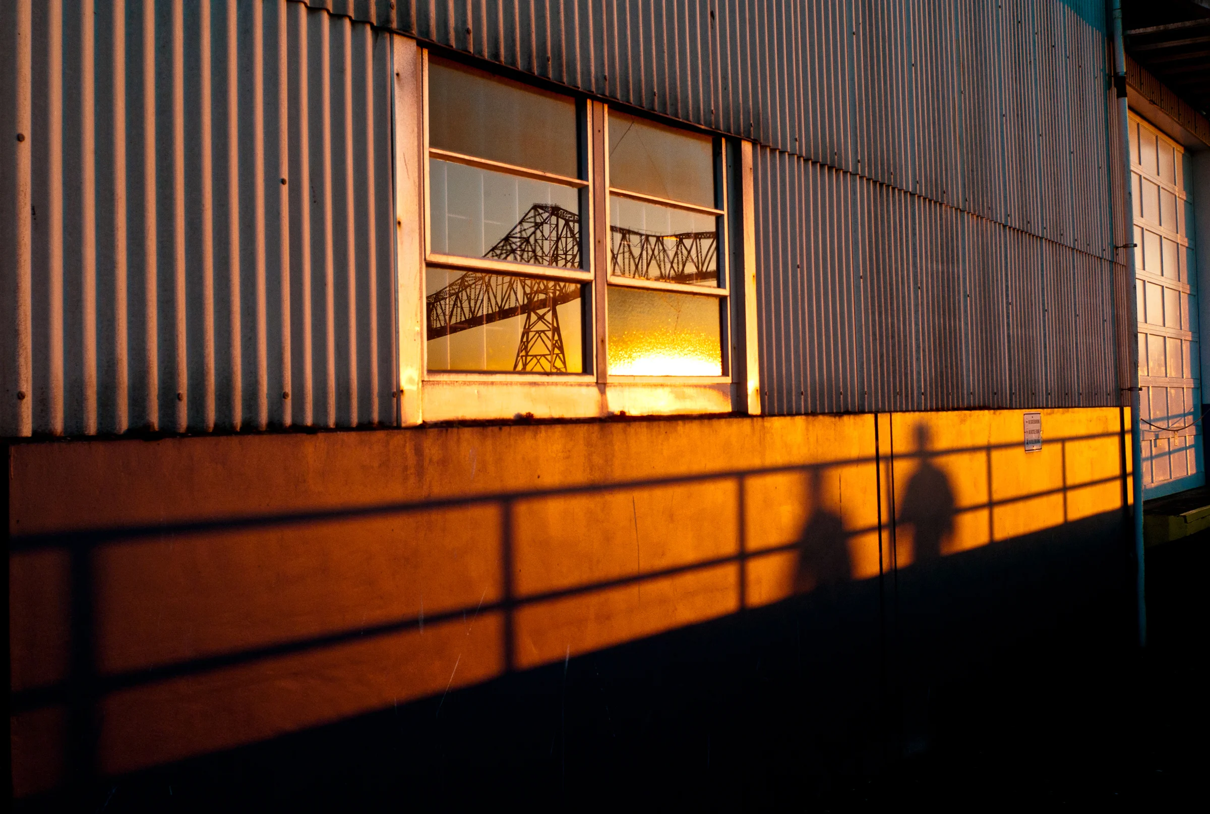 Astoria-Megler Bridge reflected in a window of Astoria Warehousing, along the Astoria Riverwalk, Astoria, Or., July 15, 2013, 8:56 p.m.