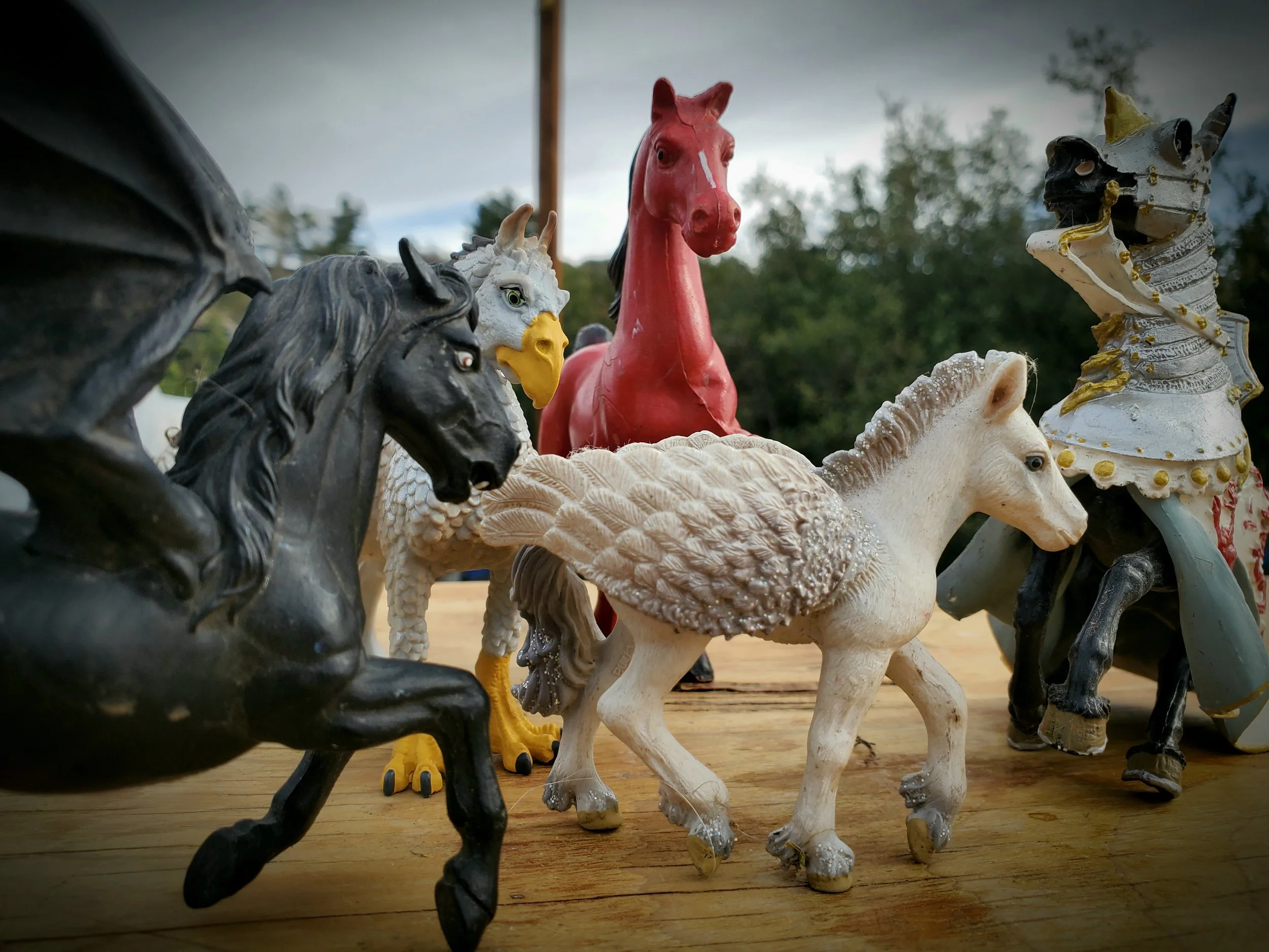 Table Top Constellation figurines arranged in a dynamic group formation on a wooden surface, used for representing systemic and relational dynamics in a remote session.