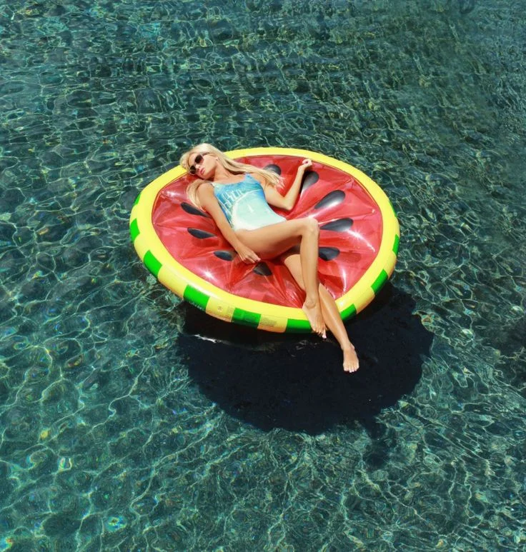 An otherwise sexy and sultry moment is injected with a big dose of fun thanks to this awesome watermelon float. Image via Barefoot Blonde