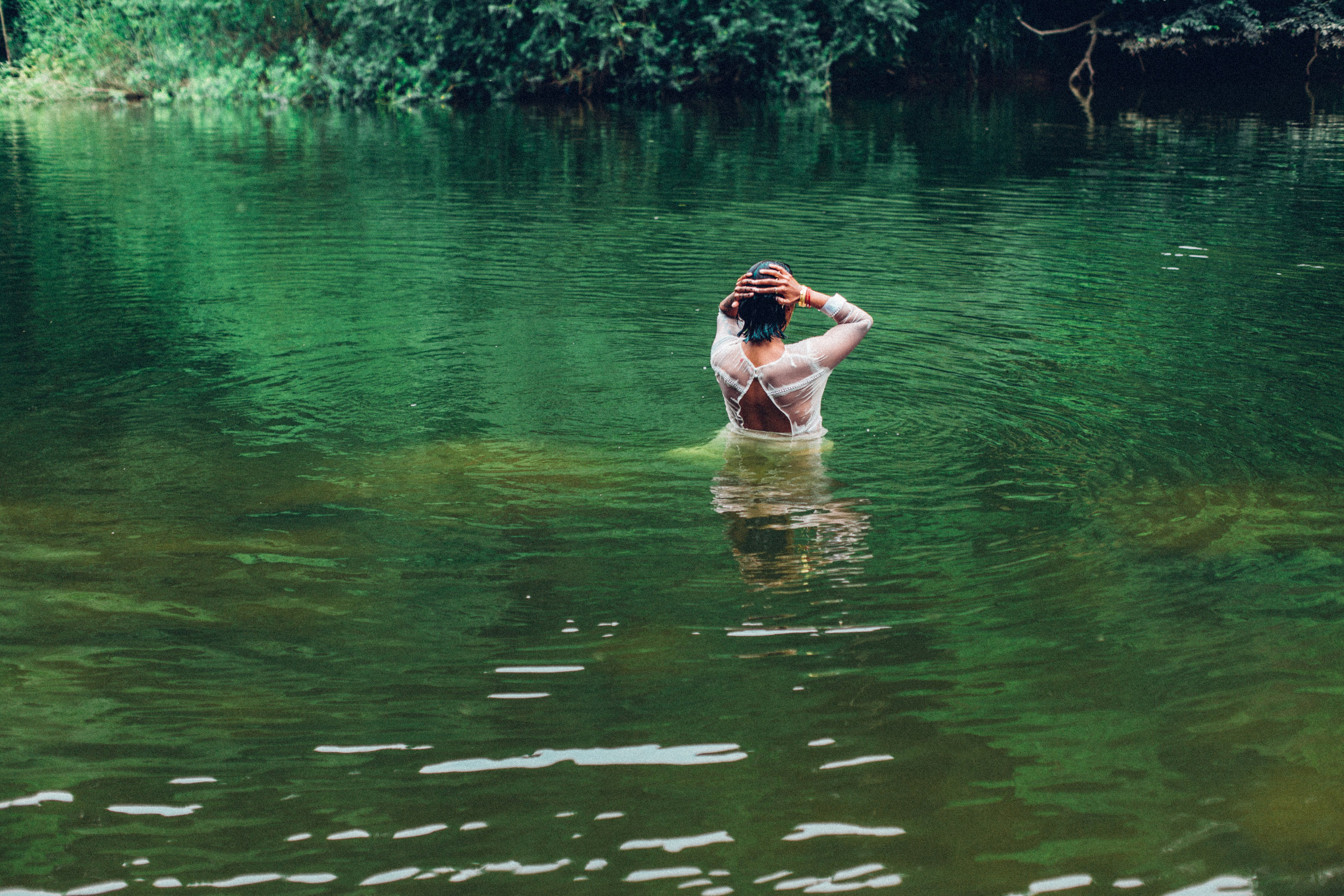  Image description: A woman is half submerged in a river 