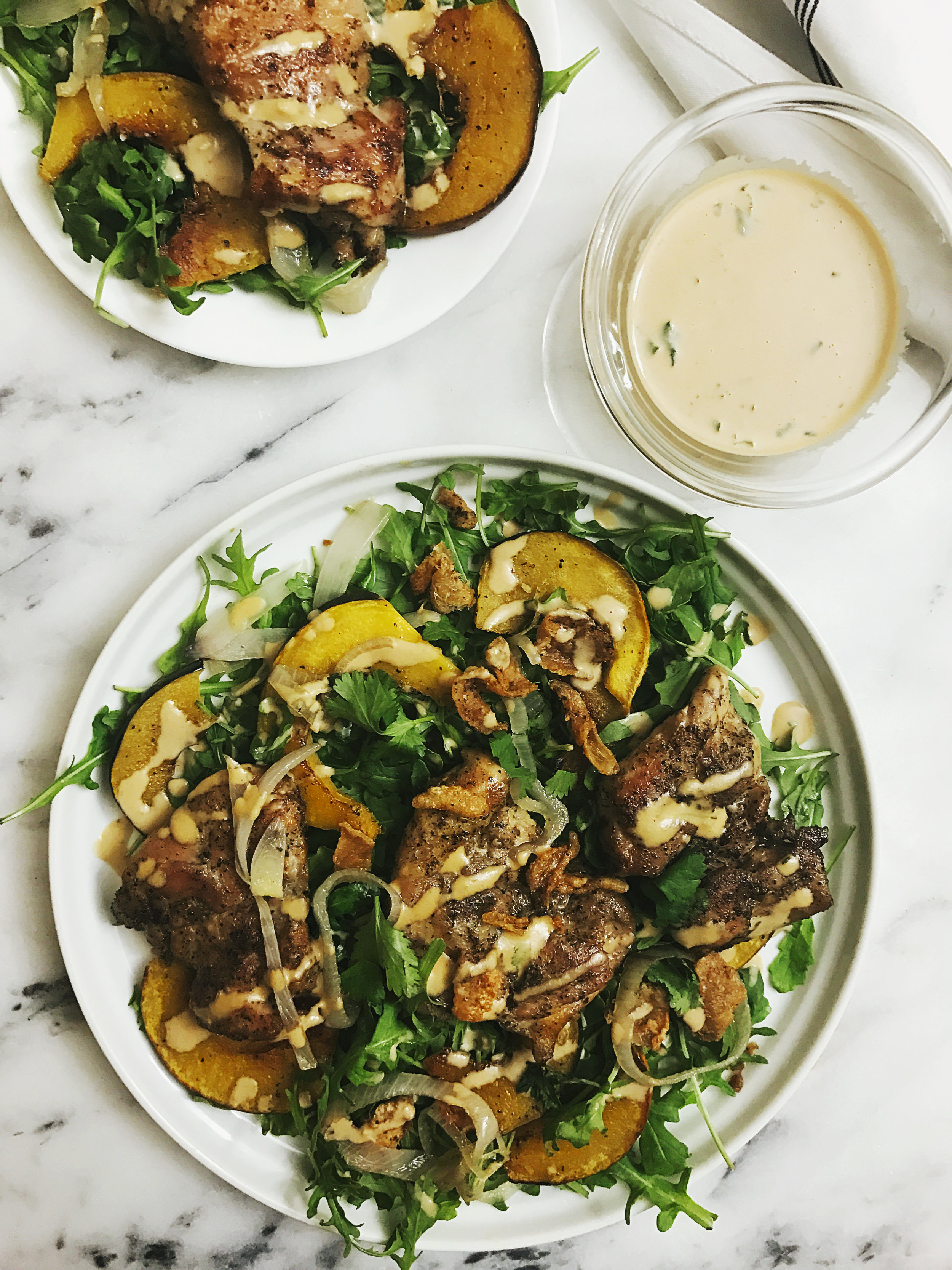 ROASTED ACORN SQUASH SALAD TOPPED WITH ROASTED BONELESS CHICKEN THIGHS AND LIME TAHINI DRESSING