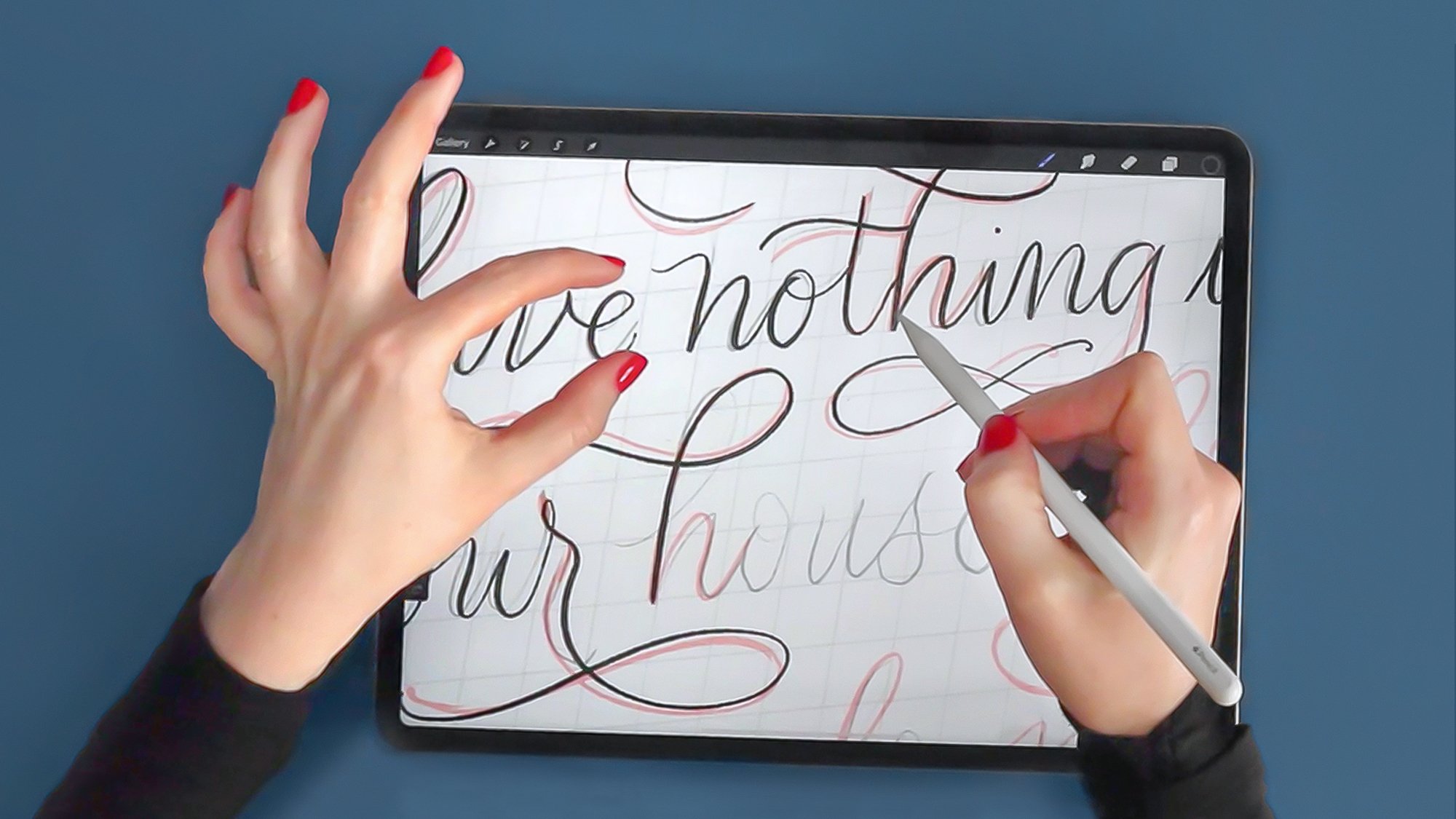 Molly Suber Thorpe’s hands drawing flourished calligraphy on her iPad, using the Procreate app and an Apple Pencil.