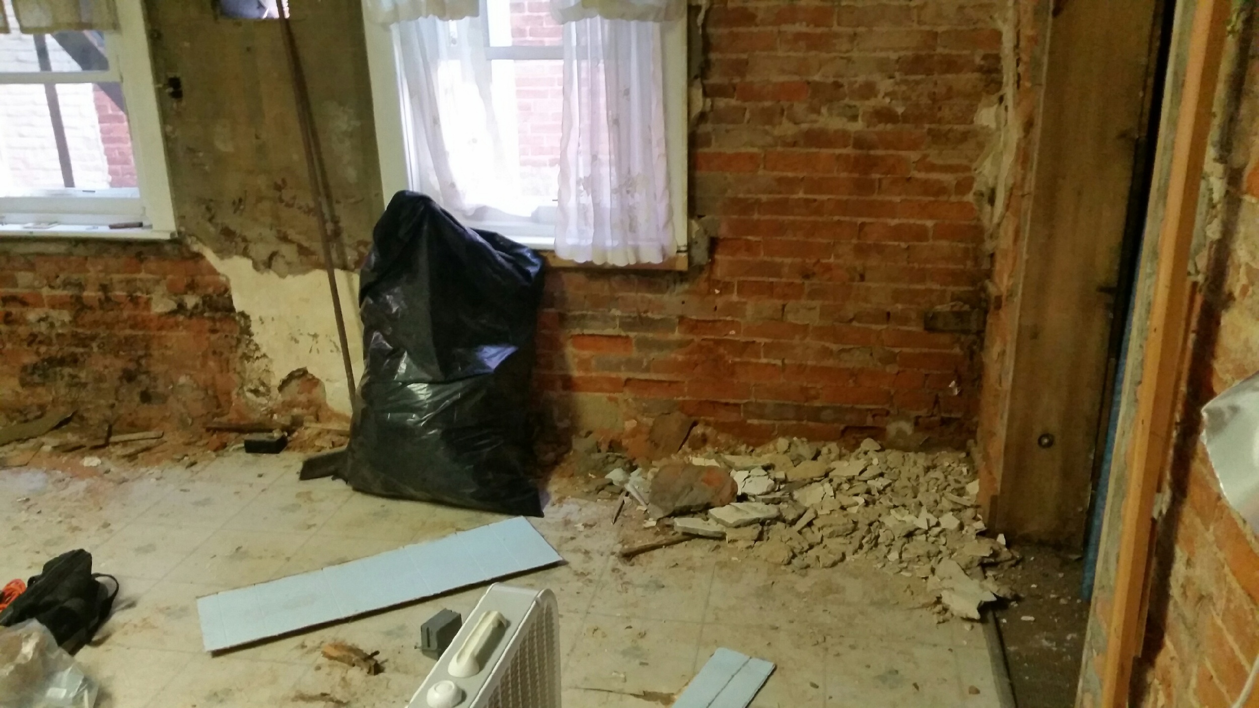 Removed layers of wall coverings to find original brick.