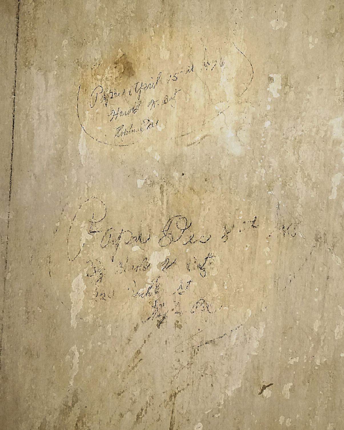 Found this writing under the wallpaper in the hallway. It's difficult to make out but it looks like the dates of when they papered the wall.