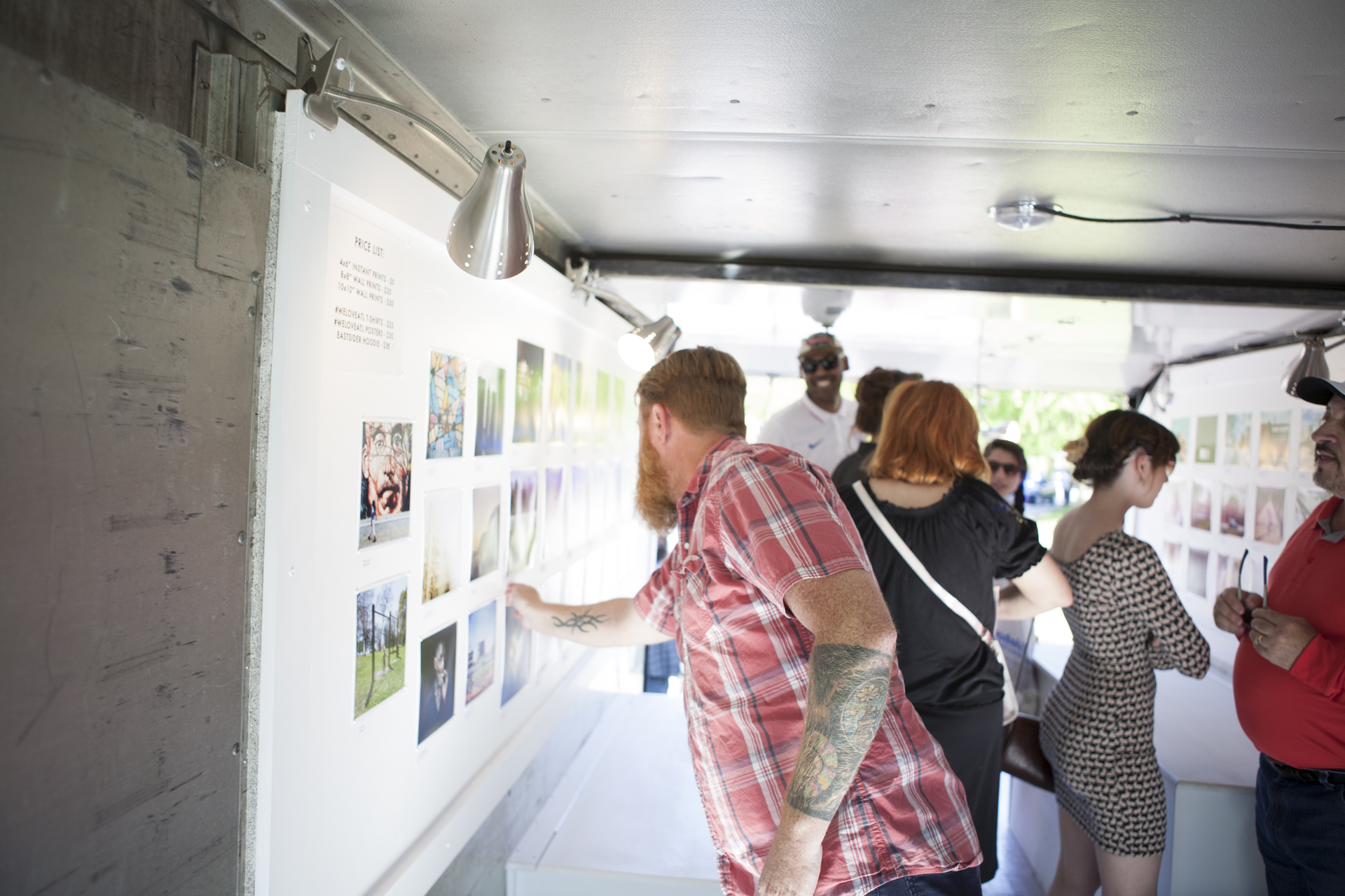Tim Moxley adjusting one of the images in the mobile gallery during the Atlanta Streets Alive event. Each print sold creates 200 meals for those in need. Photo by J.R. Ward II