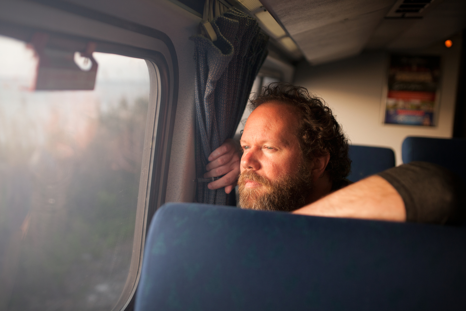 Young man looking out of train window on the historic steam engine