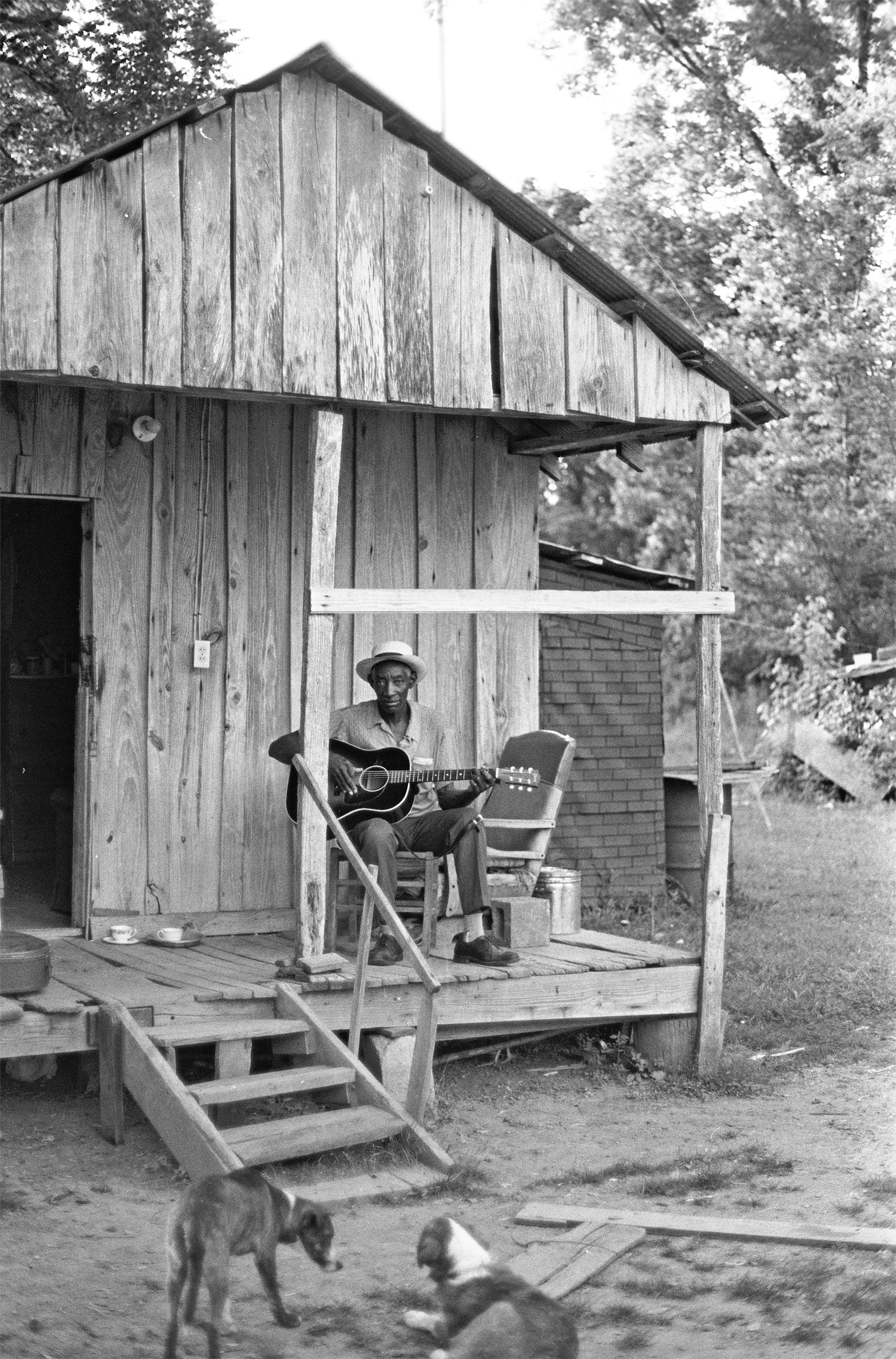 Scott Dunbar plays guitar on his ont porch.jpg