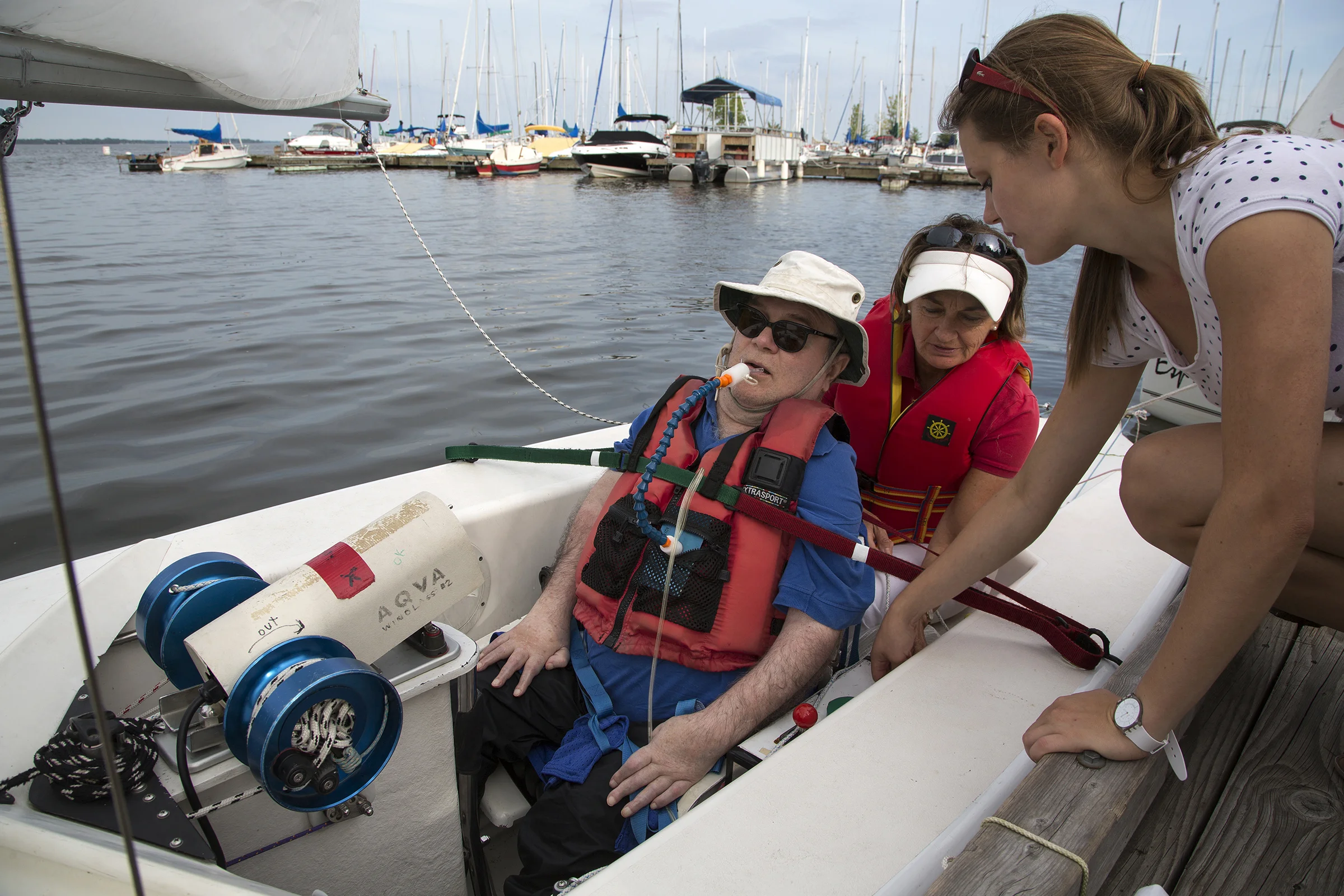 POINTE-CLAIRE, QC. AUGUST 20, 2014 -- Skipper René Dallaire, a quadriplegic and Executive Director of Association québécoise de voile adaptée, is secured into a sailboat at the Pointe Claire Yacht Club in the West Island of Montreal, along with Senneville mayor Jane Guest on Wednesday, August 20, 2014. (Leslie Schachter/West Island Chronicle, Transcontinental )