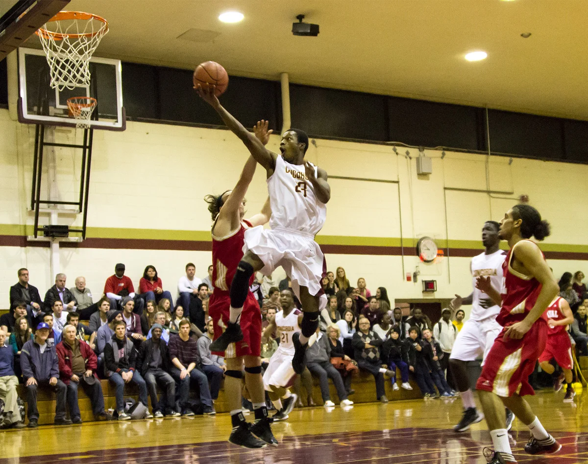 MONTREAL, QC. NOVEMBER 15, 2012 -- Laval Rouge et Or players are caught off guard as Concordia Stingers forward Evens Laroche soars towards the net in a home game at Loyola in Montreal on Thursday, November 15, 2013. The Stingers dominated the game, beating the Rouge et Or 90-62. (Leslie Schachter/THE LINK)