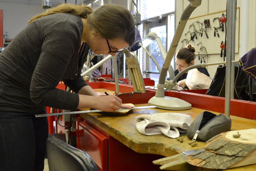 Measuring her wood slabs to be cut in the wood shop.