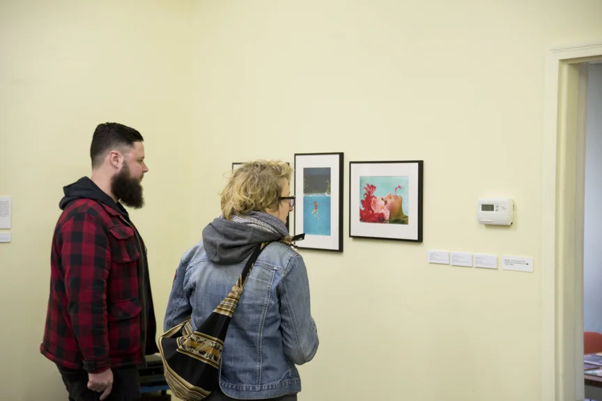 First Fridays Ypsi organizer, Kayj Michelle with a friend, checking out Janice Dicksinson.