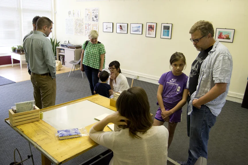 Mark Maynard and his daughter learn about the book binding process. 