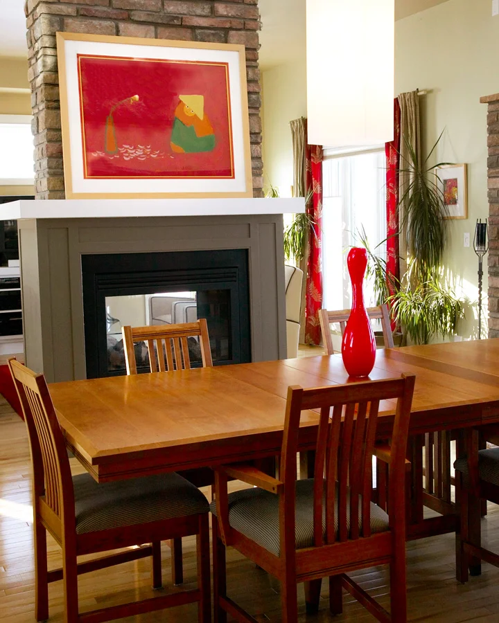 ACCENT COLOURS The red accent colour is what pulls the living and dining room together. The blonde wood on the artwork is in keeping with the simple lines of the arts and crafts style dining table.