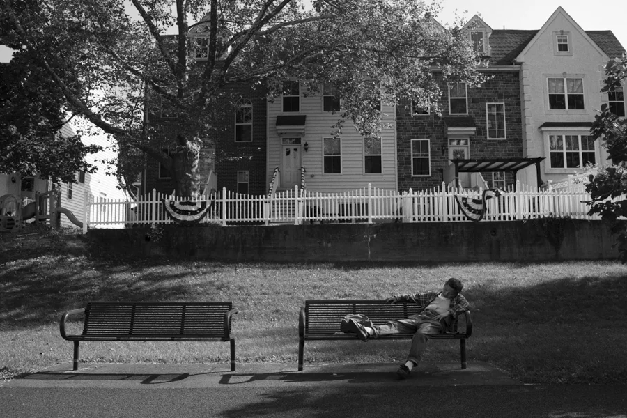 A Asian bus rider sleeps in a bench at Greenway trail, near the Sands Casino, Bethlehem, PA.