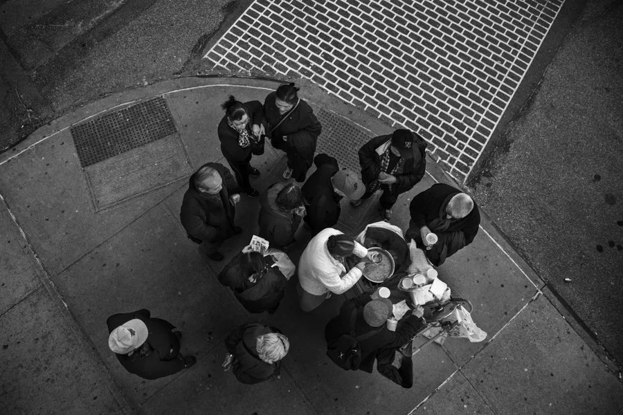 Volunteers from Love Mission House serves free bowl of soup to Asians in front of municipal parking lot in Flushing, Queens, March 22nd, 2014. Asians who wait for Casino buses takes their meal as volunteers provide meals every Saturday evening.