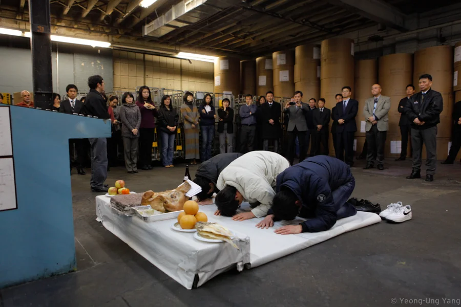 QUEENS, NY - Employees at the Korea Daily hold a rite called a gosa, New Years day in 2012. Gosa is a shamanistic ritual usually held in New Years day or when a business opens. food is offered to the spirits in order to avoid misfortune and bring good luck. Then everybody puts paper money in the pig''s mouth as a wish for success and prosperity.