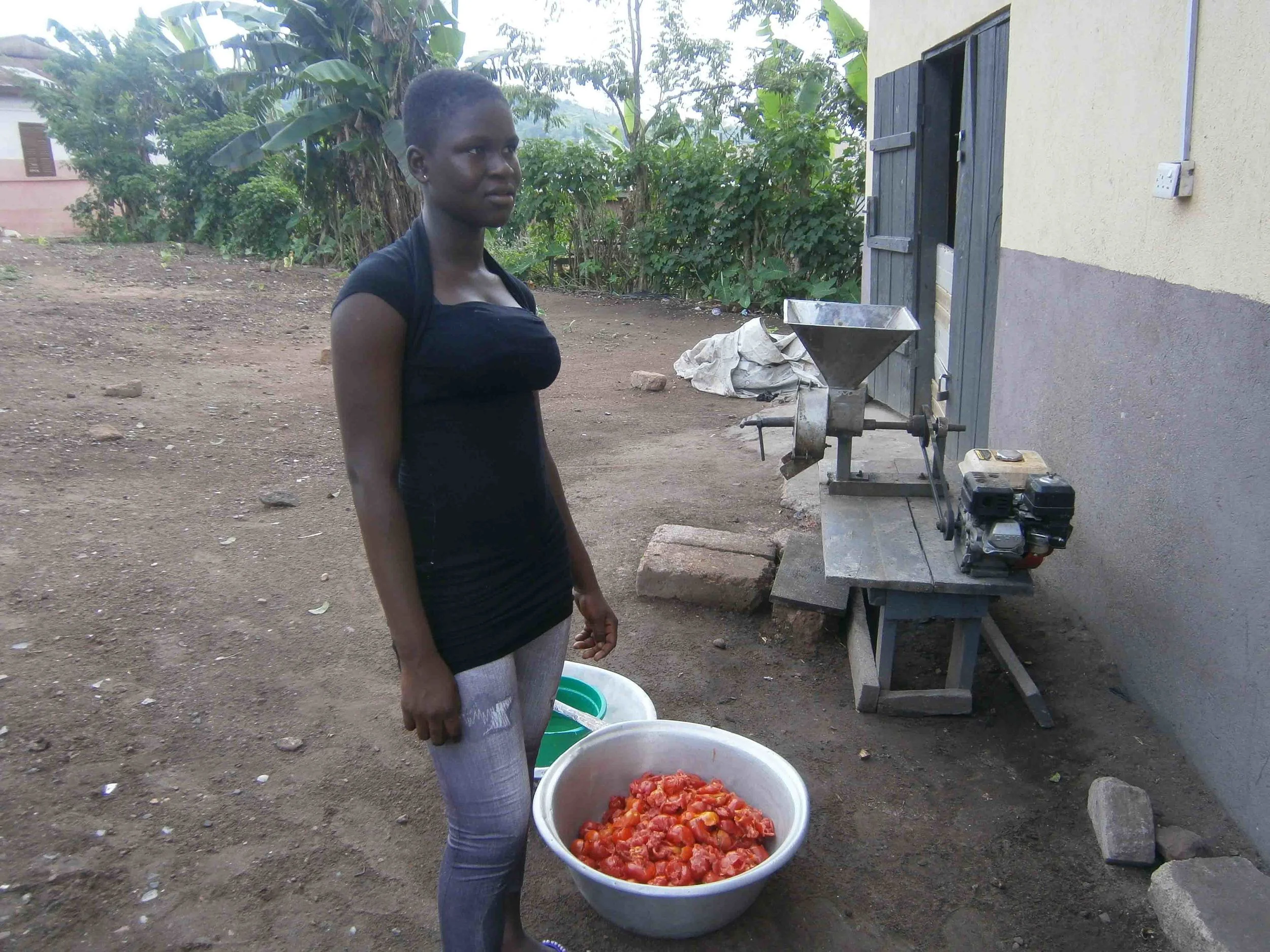  Woman brought tomatoes to the food processor to be ground up into tomato paste. &nbsp;She's brought enough tomatoes to make sauce to sell to other families in the village. 