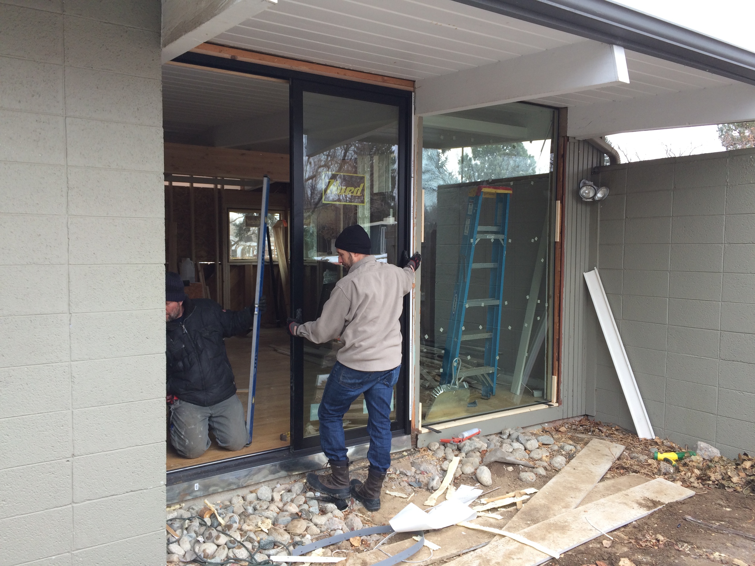 Angelo & Clint setting the new floor-to-ceiling sliding doors in the living room/side patio area