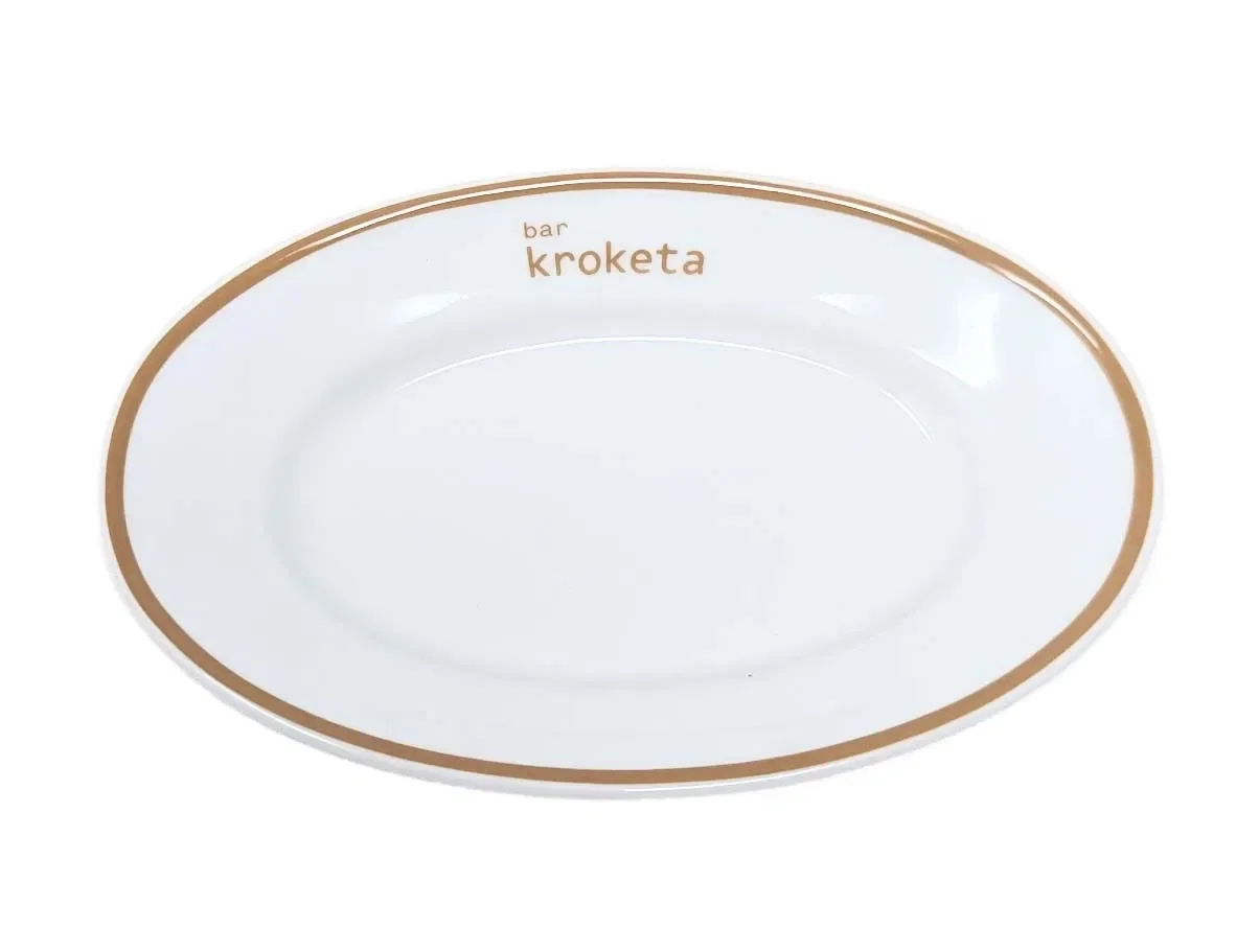 Oval white plate with a brown border and the words 'bar kroketa' printed on the rim.