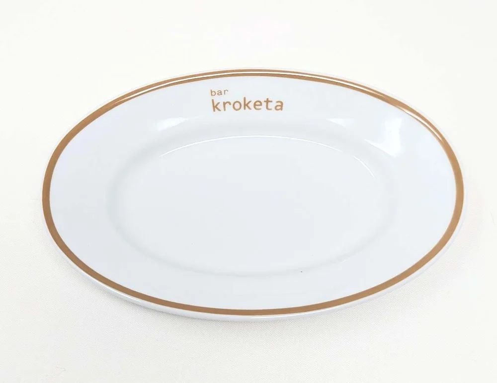 Oval plate with the Bar Kroketa logo printed on the rim