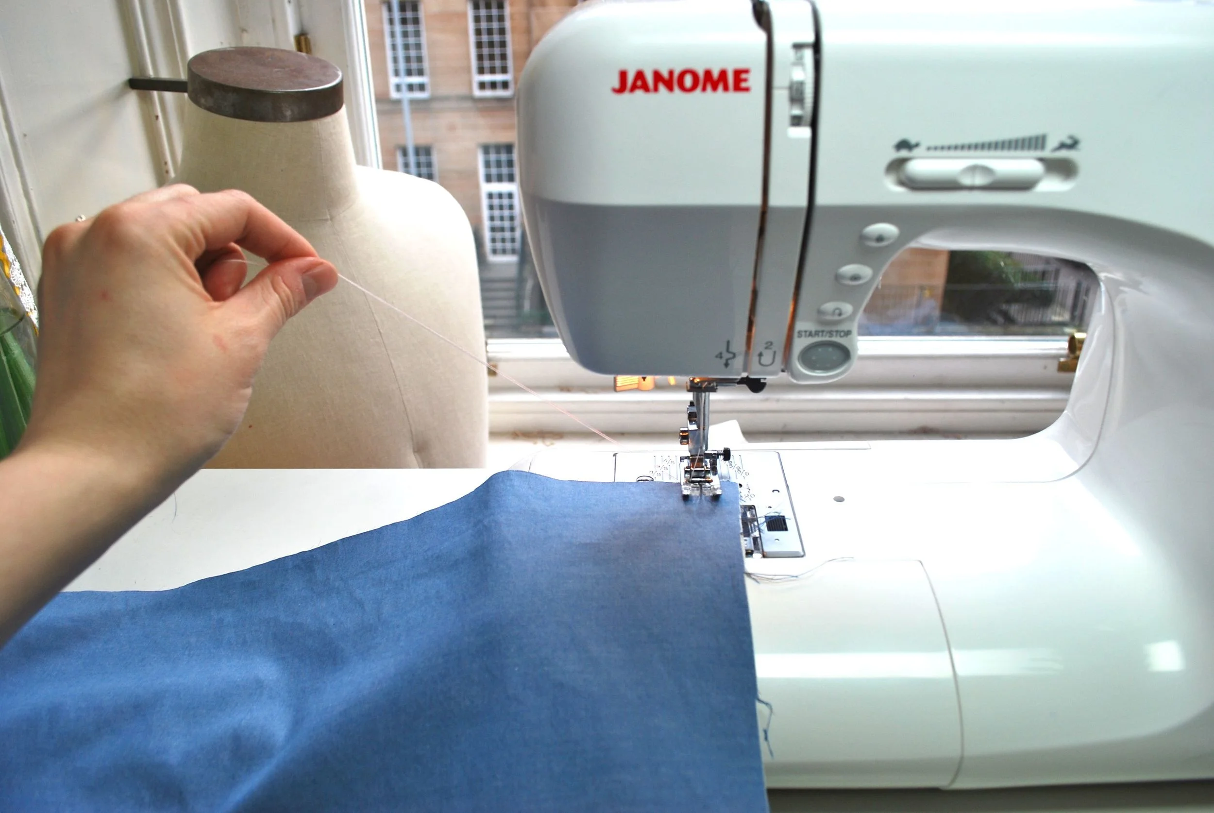Above I am pulling on the threads to make sure I leave a long thread tail when I start my gathering stitches.